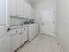 Well-equipped laundry room featuring white cabinets, a counter, and modern washer and dryer at 692 Egret Walk Ln, Venice, FL 34292