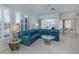Living room with ample natural light, a blue sofa, and a glass-top coffee table at 692 Egret Walk Ln, Venice, FL 34292
