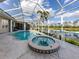 Screened-in pool and hot tub with a view of the adjacent lake at 692 Egret Walk Ln, Venice, FL 34292