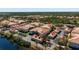 Scenic aerial view of condos with red roofs, lush landscaping and a serene pond at 7104 L Pavia Blvd # 7104, Venice, FL 34292