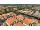 Nice aerial showcasing complex of condominiums, lawns, landscaping, and terracotta roofs at 7104 L Pavia Blvd # 7104, Venice, FL 34292