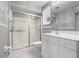 Bathroom features a glass door shower, a mirror, and white cabinets at 7104 L Pavia Blvd # 7104, Venice, FL 34292