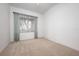 Empty bedroom with neutral carpet and window with blue curtains at 7104 L Pavia Blvd # 7104, Venice, FL 34292