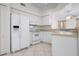 Bright kitchen with white cabinets, a refrigerator, microwave, and a view into the adjacent living area at 7104 L Pavia Blvd # 7104, Venice, FL 34292