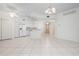 Open living area with tile floors, white walls, and a ceiling fan, connected to the kitchen at 7104 L Pavia Blvd # 7104, Venice, FL 34292