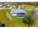 A home with a pool and screened enclosure surrounded by green lawns and a beautiful tree at 7407 S Blue Sage, Punta Gorda, FL 33955