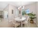 Bright dining room with a white oval table, upholstered chairs, modern chandelier and big windows at 7407 S Blue Sage, Punta Gorda, FL 33955