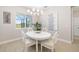 Bright dining room with white oval table, upholstered chairs, modern chandelier, and large window at 7407 S Blue Sage, Punta Gorda, FL 33955
