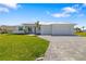 Stunning one-story home featuring a well-manicured lawn, metal roof, and a paver driveway at 7407 S Blue Sage, Punta Gorda, FL 33955