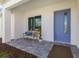 Inviting front porch with a bench and modern blue front door on a paved walkway at 7407 S Blue Sage, Punta Gorda, FL 33955