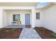 Charming front porch with a sitting bench, tiled floor, and modern blue front door at 7407 S Blue Sage, Punta Gorda, FL 33955