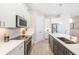 An open kitchen features white cabinets, stainless steel appliances, and a gray island with modern countertops at 7407 S Blue Sage, Punta Gorda, FL 33955