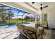 Screened-in patio featuring comfortable seating with a ceiling fan overlooking the sparkling pool and backyard at 7407 S Blue Sage, Punta Gorda, FL 33955