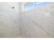 Marble-look tiled walk-in shower features a window and showerhead at 7407 S Blue Sage, Punta Gorda, FL 33955