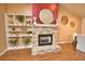 Stylish stone fireplace creating a cozy focal point, complemented by a built-in bookshelf and wood flooring at 7941 Pineglen Ct # 37, Sarasota, FL 34238