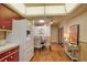 A kitchen opens up to a dining area with table and chairs, illuminated by modern lighting at 7941 Pineglen Ct # 37, Sarasota, FL 34238