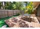 Cozy backyard patio with outdoor dining set, privacy fence and lush greenery at 7941 Pineglen Ct # 37, Sarasota, FL 34238