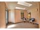 The sunroom has two chairs and a small table and has lots of natural light coming through the skylights at 7941 Pineglen Ct # 37, Sarasota, FL 34238