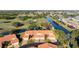 Aerial view of townhomes highlighting the red roofs and waterway views at 867 Country Club Cir #71, Venice, FL 34293