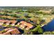 Stunning aerial view of a single-Gathering home on a lush golf course with pond and mature trees at 867 Country Club Cir #71, Venice, FL 34293