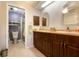 Bathroom with dual sinks, modern tile floors, and a glass door shower at 867 Country Club Cir #71, Venice, FL 34293