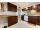 Functional kitchen with tile floors, dark cabinets, and white appliances at 867 Country Club Cir #71, Venice, FL 34293