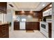 Efficient kitchen featuring dark cabinets, tiled backsplash, and modern appliances at 867 Country Club Cir #71, Venice, FL 34293