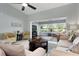 Open-concept living room with tile floors, golf course views, comfortable seating, and a ceiling fan at 867 Country Club Cir #71, Venice, FL 34293