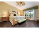 Cozy main bedroom with warm colors, wood floors, and backyard view at 867 Country Club Cir #71, Venice, FL 34293