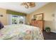 Bright main bedroom with floral bedding, wood floors, and a backyard view at 867 Country Club Cir #71, Venice, FL 34293