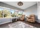 Bright sunroom features large windows, comfortable seating, and a view of the outdoors at 867 Country Club Cir #71, Venice, FL 34293