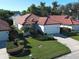 Aerial view of a well-maintained home with a red tile roof and a beautifully landscaped front yard at 904 Harbor Town Dr, Venice, FL 34292