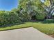 Lush backyard with mature landscaping and a concrete patio area at 904 Harbor Town Dr, Venice, FL 34292