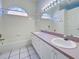 Well-lit bathroom with arched windows, double sinks, and ample counter space at 904 Harbor Town Dr, Venice, FL 34292