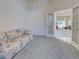 Carpeted bedroom featuring a couch, ceiling fan, and French doors leading to the main living area at 904 Harbor Town Dr, Venice, FL 34292