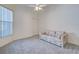 Cozy bedroom with a comfortable couch, plush carpeting, and a ceiling fan for added comfort at 904 Harbor Town Dr, Venice, FL 34292