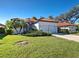 Charming single-story home with a red tile roof and well-manicured lawn with lush greenery at 904 Harbor Town Dr, Venice, FL 34292