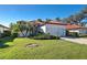 Charming single-story home with a red tile roof and well-manicured lawn with lush greenery at 904 Harbor Town Dr, Venice, FL 34292