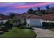 Charming single-story home with a red tile roof, a well-manicured lawn and mature landscaping at 904 Harbor Town Dr, Venice, FL 34292