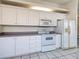 Well-maintained kitchen with white cabinetry, appliances, and tile flooring at 904 Harbor Town Dr, Venice, FL 34292
