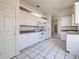 Well-lit kitchen boasts white cabinetry and appliances with an adjacent dining area at 904 Harbor Town Dr, Venice, FL 34292