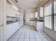 Spacious kitchen featuring white cabinets and appliances, complemented by light, tiled floors at 904 Harbor Town Dr, Venice, FL 34292
