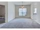 Open-concept living room featuring neutral carpet, natural light, and a ceiling fan at 904 Harbor Town Dr, Venice, FL 34292