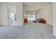 A spacious living room features carpeted floors, a ceiling fan, and sliding glass doors to the pool at 904 Harbor Town Dr, Venice, FL 34292