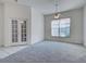 Spacious carpeted Living Room featuring French doors, ceiling fan and large windows at 904 Harbor Town Dr, Venice, FL 34292