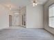 Bright Living Room leads to Foyer and Bedroom with large windows, ceiling fan, and plush carpet at 904 Harbor Town Dr, Venice, FL 34292