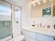 Clean and bright bathroom featuring a glass door shower, white cabinets, and a large mirror at 919 Key Way, Nokomis, FL 34275