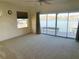 Bedroom featuring waterfront views through a large sliding glass door, ceiling fan, and carpeted floor at 919 Key Way, Nokomis, FL 34275