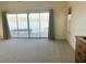 Bedroom with waterfront views from large sliding glass doors, ceiling fan, and neutral carpeting at 919 Key Way, Nokomis, FL 34275