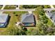 A tranquil aerial view of a screened pool home with lush landscaping and a cozy backyard firepit area at 951 Sea Fox Rd, Venice, FL 34293